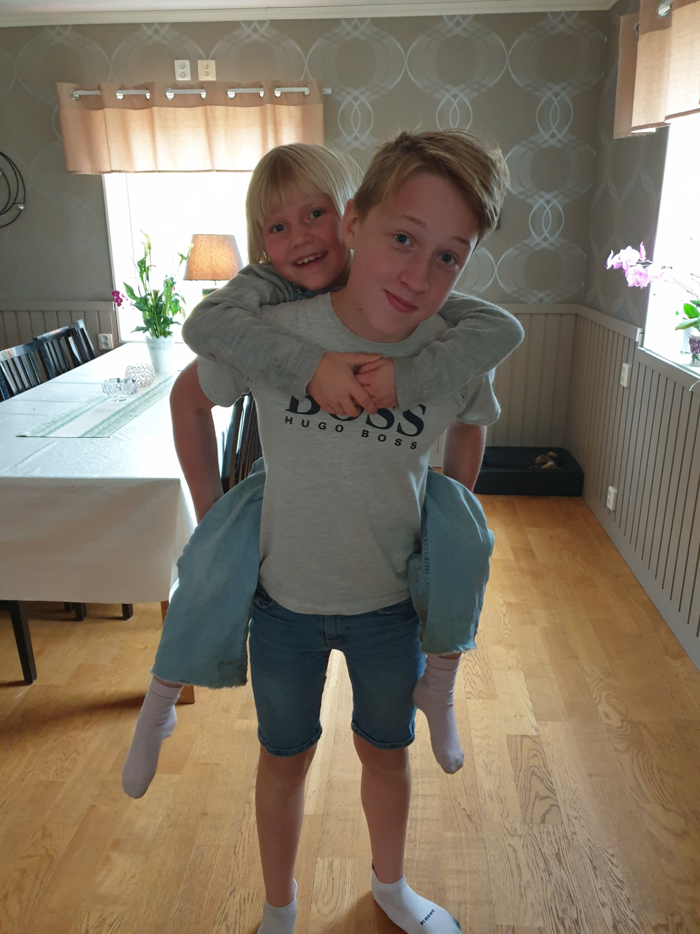 Nathan bär ett av sina småsyskon på ryggen hemma